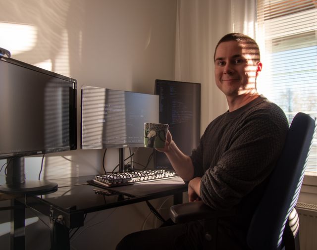 Jere Huttunen posing at his desk beside the Vaihe homepage on his monitor